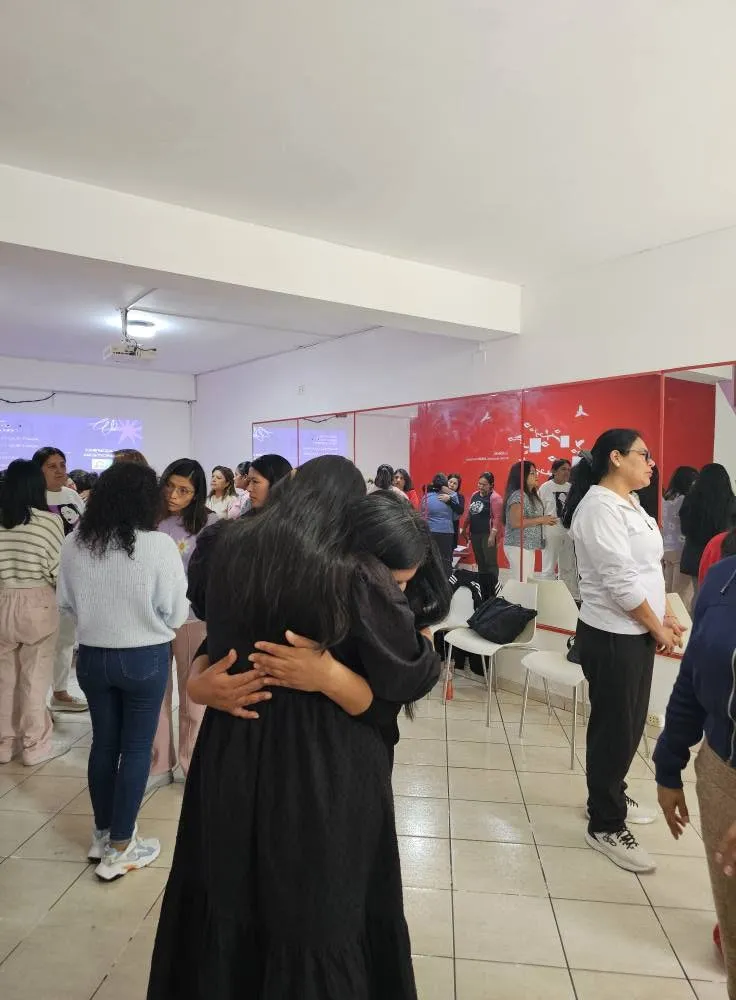 Dos participantes se abrazan durante una actividad